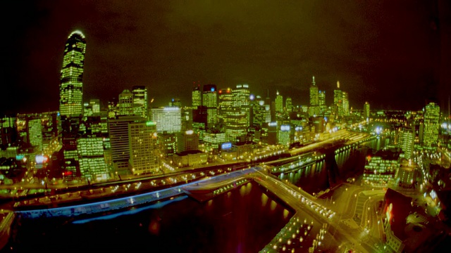 高角度广角拍摄时间推移交通+云前面的墨尔本天际线在晚上/澳大利亚维多利亚视频素材