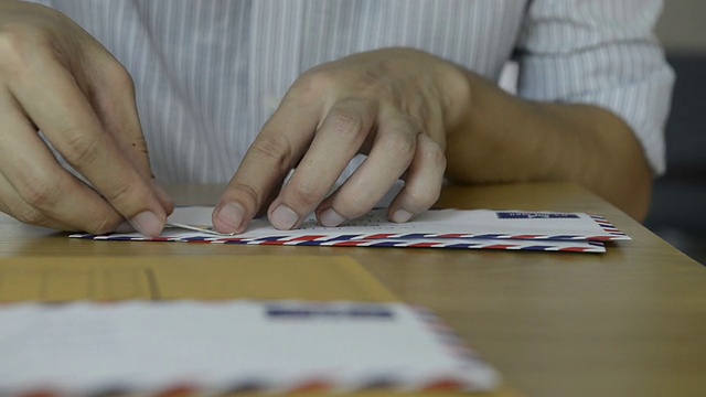 人们在信件和包裹上贴邮票视频素材