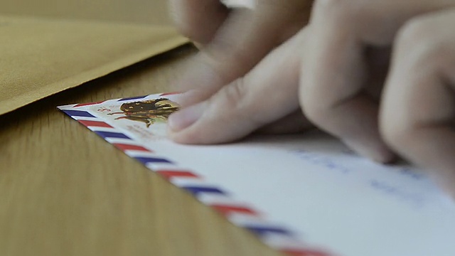 人们在信件和包裹上贴邮票视频素材