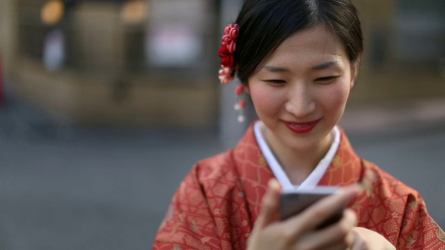 日本女孩穿着和服笑着发短信在涉谷视频素材