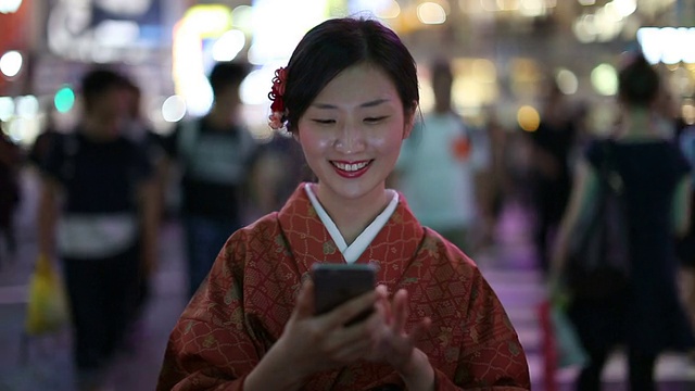 身着和服的日本女孩在涉谷十字路口发短信视频素材