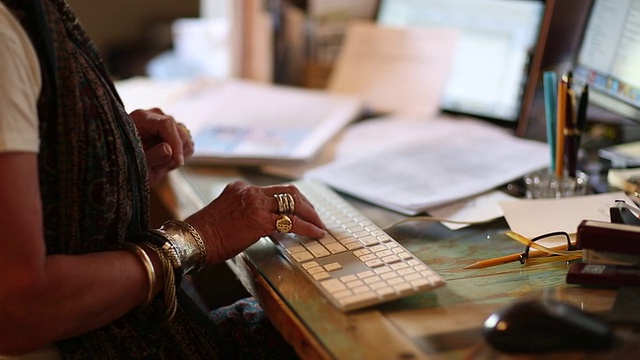 资深女性小企业主在她的台式电脑上打字视频素材