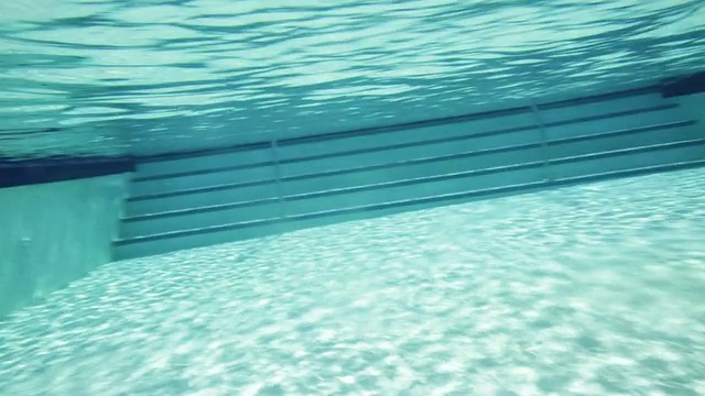 男子在泳池中蝶泳，水下侧景拍摄视频下载