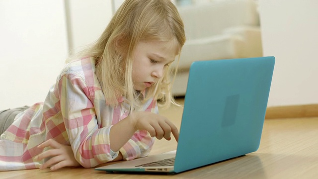 小女孩在家里使用笔记本电脑视频素材