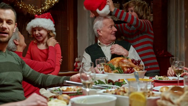 孙辈和祖父母在圣诞餐桌上玩得很开心视频素材