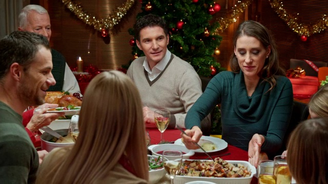 家庭成员在圣诞餐桌上分享食物视频素材