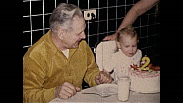1972年2岁女孩和祖父母一起吃生日蛋糕的家庭电影视频下载