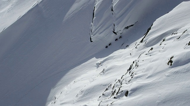 空中拍摄的滑雪登山者攀登狭窄的降落伞在阿拉斯加视频素材