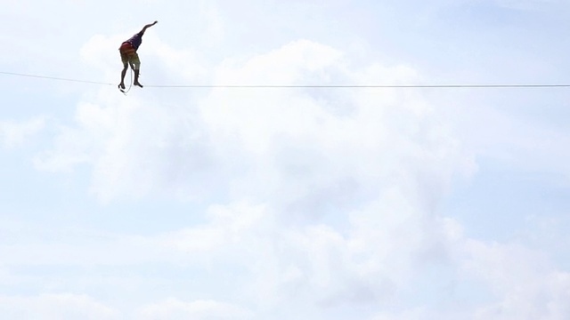 运动员沿着悬挂在海面上的高空绳索行走视频下载