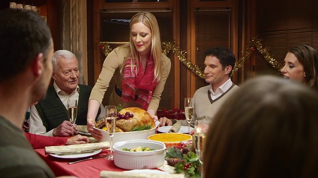 在圣诞餐桌上服侍火鸡的女人的SLO MO视频素材
