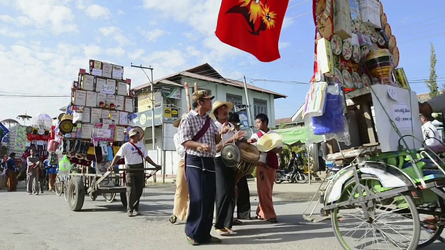 缅甸掸邦茵莱湖尼翁瑞庙会上，音乐家和僧侣在自行车车上的游行和捐赠视频下载