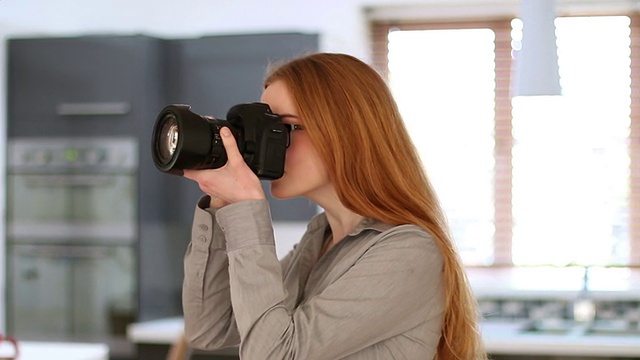 年轻女子使用单反相机，室内摄影。视频下载