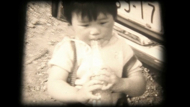60年代的8毫米镜头，小男孩用吸管喝酒视频素材