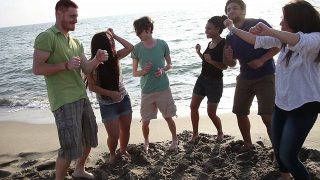 一群朋友在海滩上跳舞视频素材