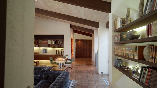 DS穿过书架进入了宽敞的客厅，里面有1971年的家具和大教堂天花板视频素材