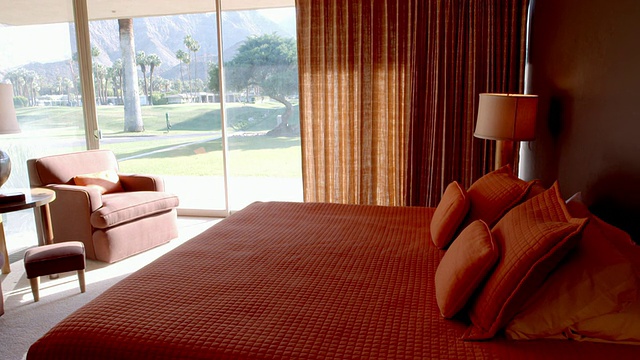 TS是一间中世纪风格的现代卧室，带有落地玻璃窗和滑块门，可以俯瞰乡村高尔夫球场视频下载