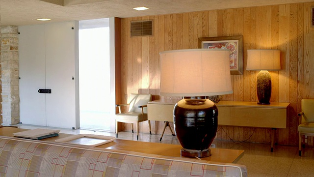 DS在20世纪50年代的客厅内部配备定制的超长沙发、灯具和天然石材壁炉墙视频下载