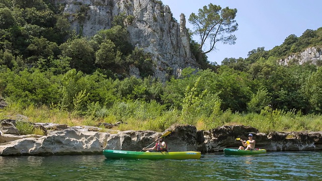 年轻的女子和男子在法国普罗旺斯的加德河上划独木舟视频下载
