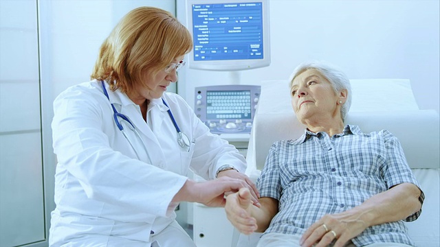 女医生检查这位老年妇女的腕部脉搏视频素材