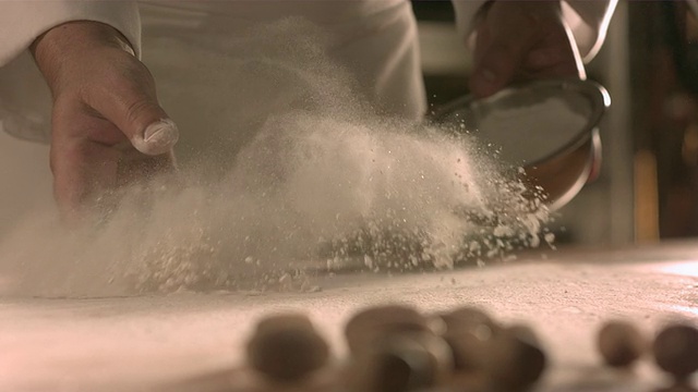 厨师将面粉撒在餐桌上。视频素材