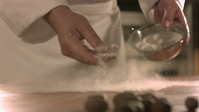 厨师将面粉撒在餐桌上。视频素材
