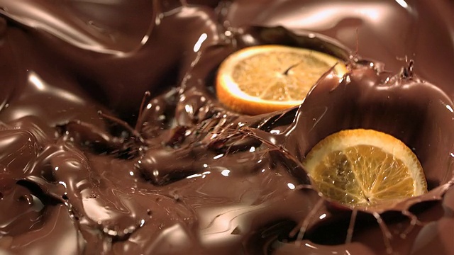 橙子片落入融化的巧克力中视频素材