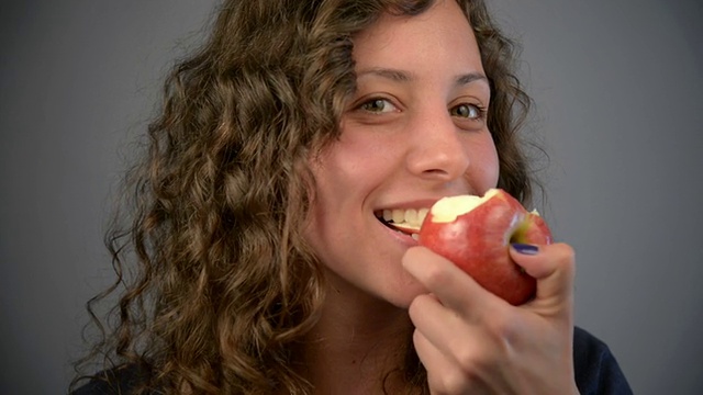 年轻女子吃红苹果。视频素材