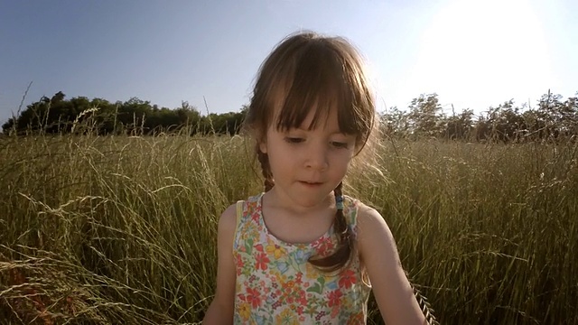 一个孩子在麦田里玩耍。镜头鉴赏力，梦幻般的眼神，慢动作。视频素材