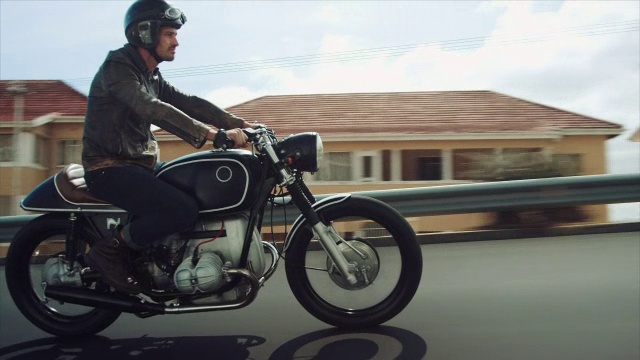 一个男人骑着摩托车穿过城市视频下载