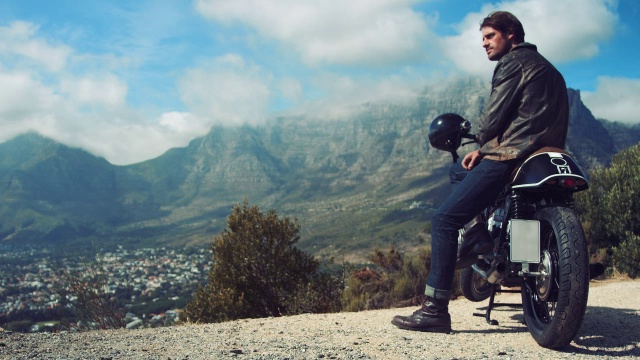 一个骑着摩托车的男人在山路上视频素材