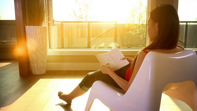 女人放松在傍晚的太阳阅读一本书视频下载