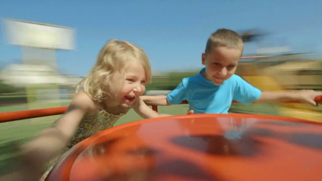 高清:两个孩子在操场上玩轮子视频素材