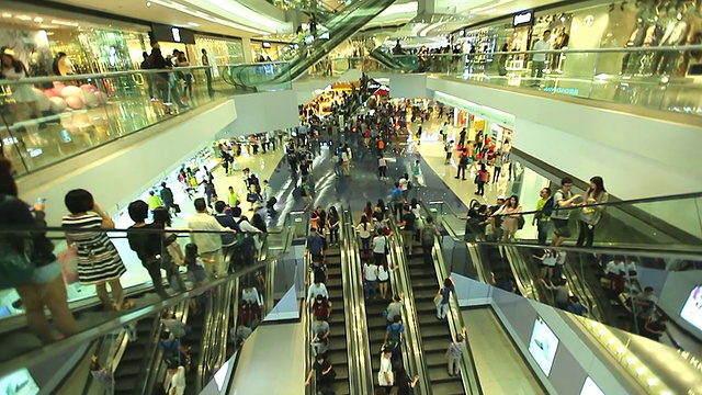 商场里拥挤的人在自动扶梯上移动。视频下载