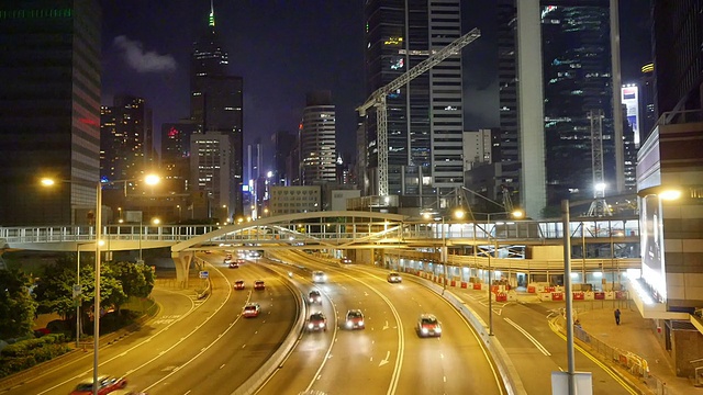 香港多车道公路和建筑物上的繁忙交通，在晚上，实时。视频素材
