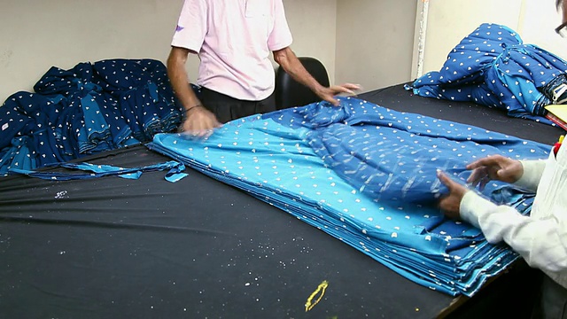 在印度北方邦诺伊达一家纺织厂工作的工人视频素材