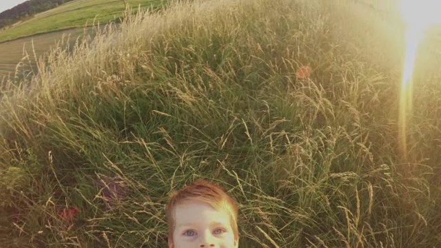 POV在草地上旋转可爱的男孩视频素材