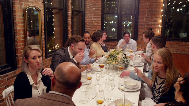 一群朋友在阁楼聚会时一起吃饭聊天视频素材