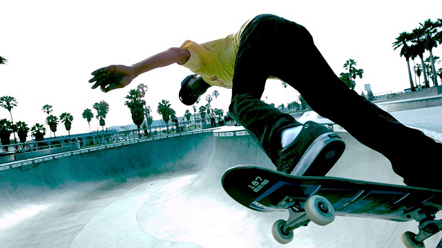 WS SLO MO拍摄的盖伊沿着顶部滑板公园碗/威尼斯，加州，美国视频下载