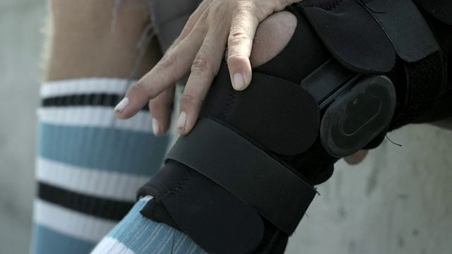 CU SLO MO TU拍摄的男子调整腿支架/威尼斯，加利福尼亚，美国视频下载