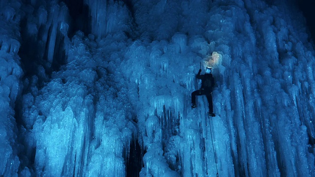 冰攀登者在美妙的夜光中攀登斜坡视频素材