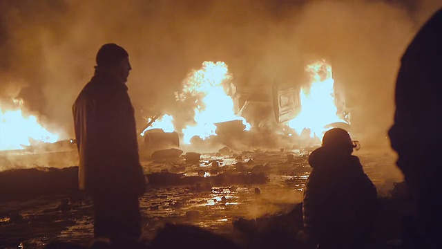 抗议者站在燃烧的货车前视频素材