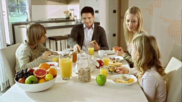 一家人在漂亮的餐桌前吃早餐视频下载