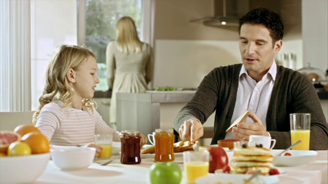 女孩在早餐时向父亲解释一些事情视频素材