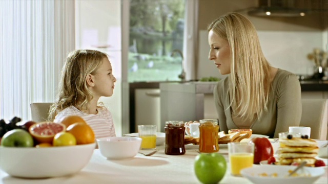 妈妈和女儿在早餐桌上聊天视频素材