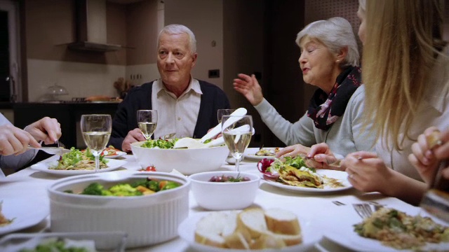一家人在餐桌上享受着吃饭聊天的乐趣视频下载