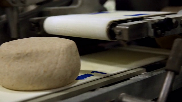 在面包工厂的生产线上移动的面团球视频素材