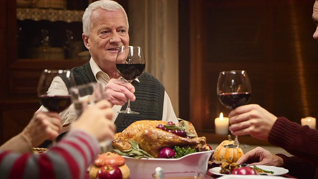 祖父在感恩节餐桌上与家人碰杯视频素材