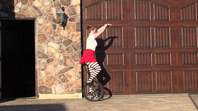 马戏团演员在屋外练习独轮车舞视频下载