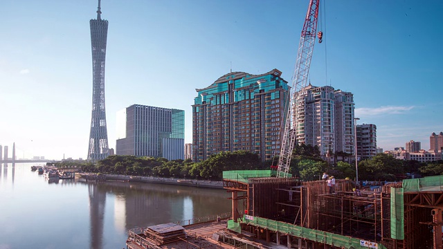 繁忙的施工现场和起重机在现代城市广州的河堤上，时光流逝。视频素材