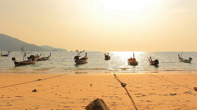 高清多莉:日落海滩上的长尾船视频素材